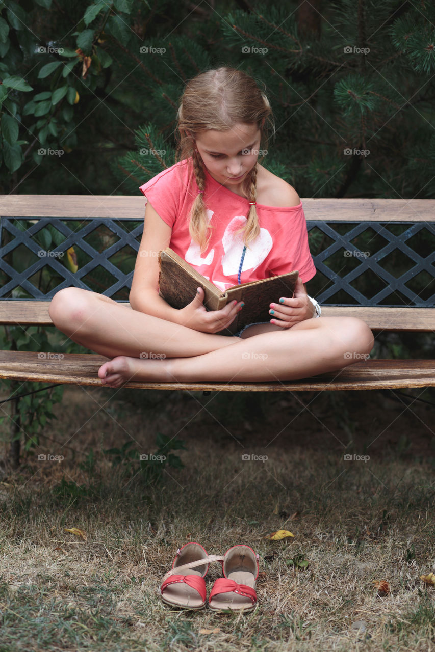 Girl reading a book on a bench