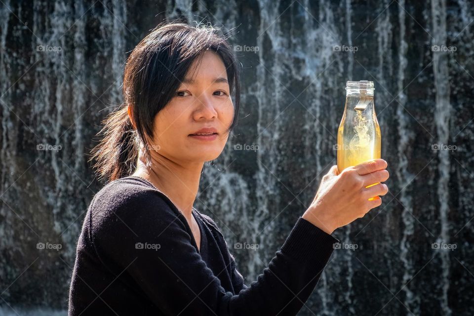 A Taiwanese lady enjoys her shilajit by the waterfall. 