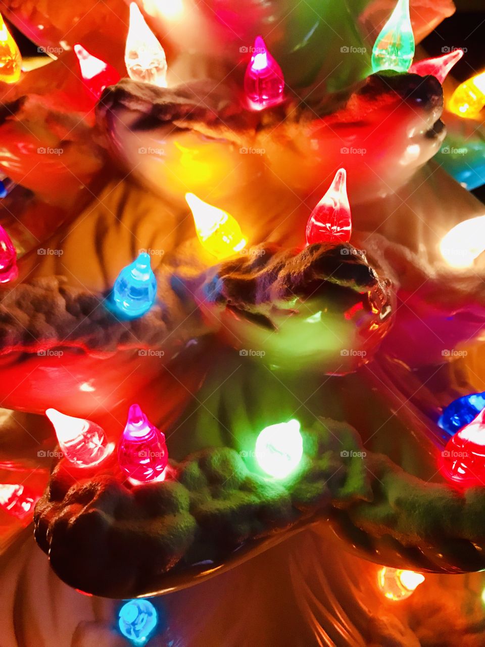 Vintage white ceramic Christmas tree with colorful lights up close 