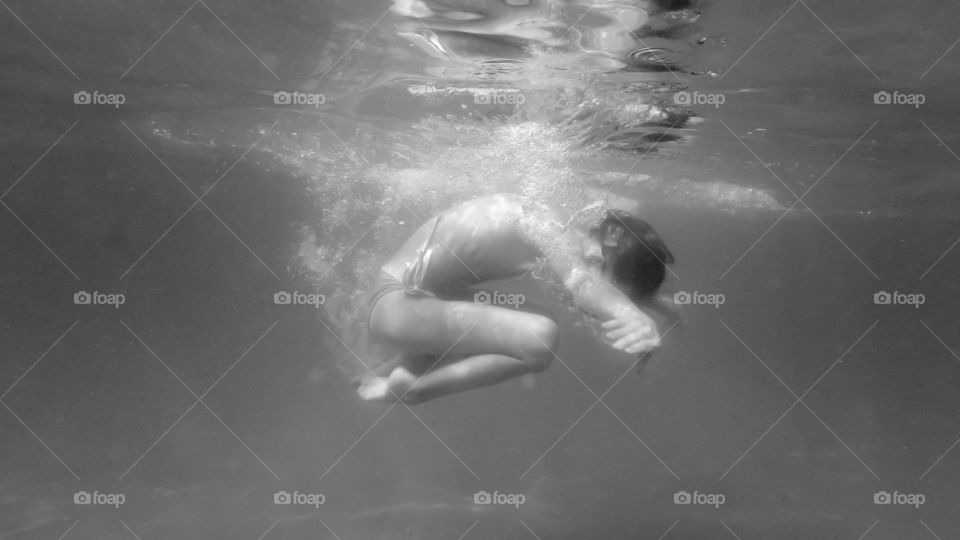young girl spinning underwater in the sea