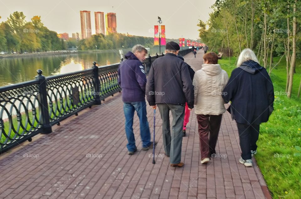 This group of older people was walking by. All of them were listenibg one man who fervently was saying something.