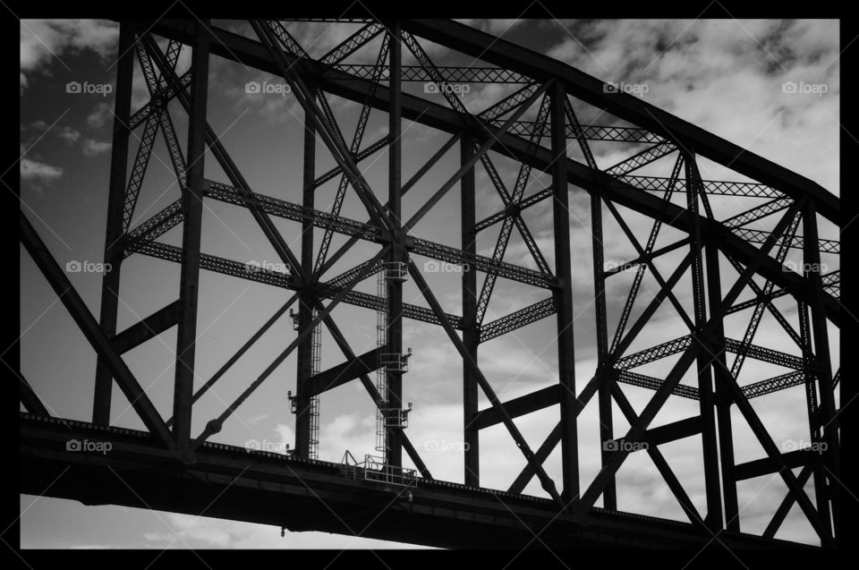 Steel truss bridge with cloudy sky over Mississippi River in Black and white 