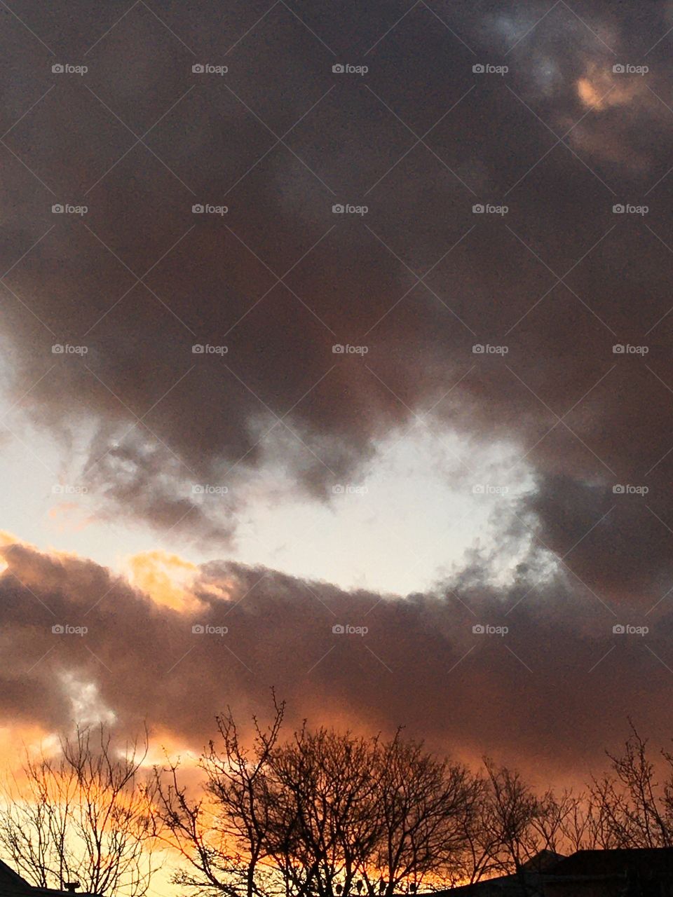 Sunset with heavy clouds and trees