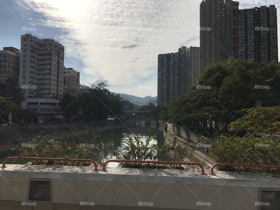 Hong Kong street view, looking at the river from bridge, claim water, tall buildings 