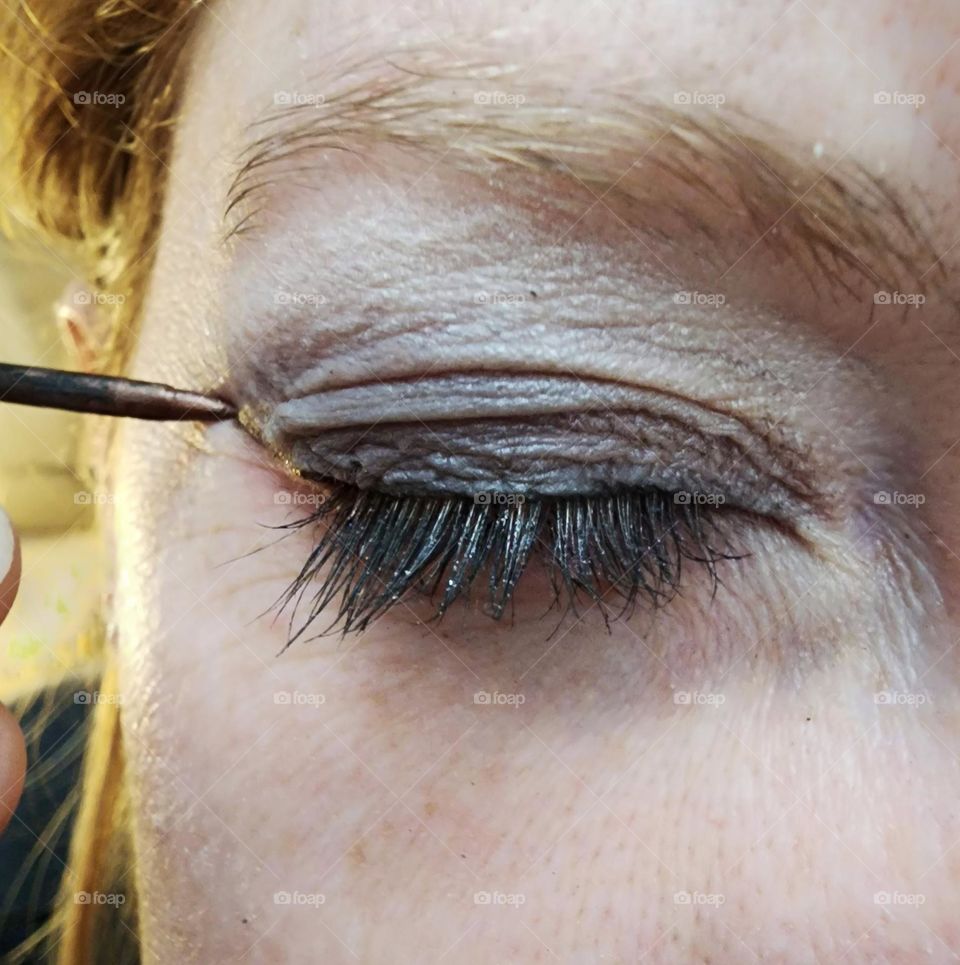 Eye makeup- applying eyeliner for the finishing touch.