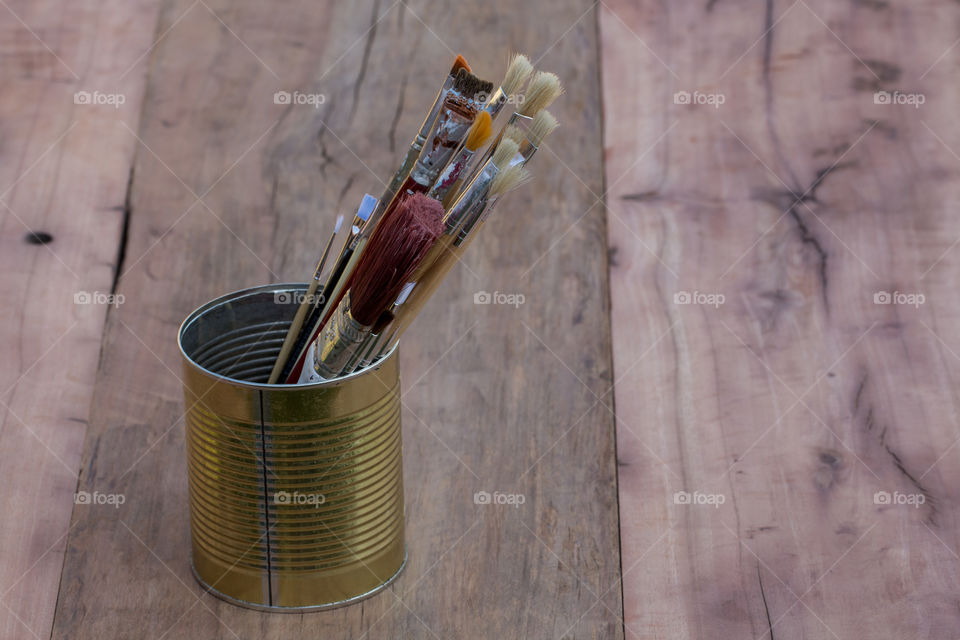 Multiple paint brushes in the paint tin