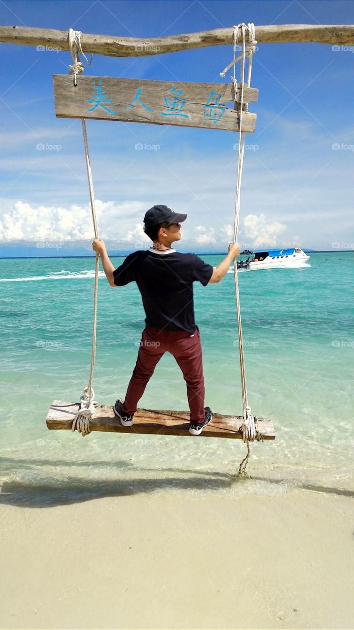 Standing on the board and swinging on the beach