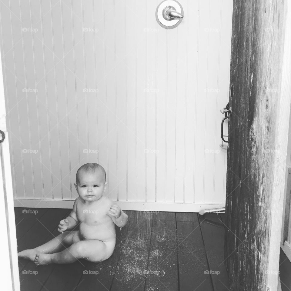 Naked baby enjoying an outdoor shower. Summer best. 
