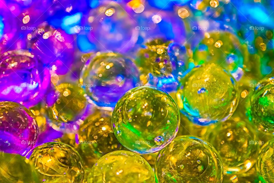 Colorful shiny glass marbles reflecting a rainbow of colors, closeup macro image 