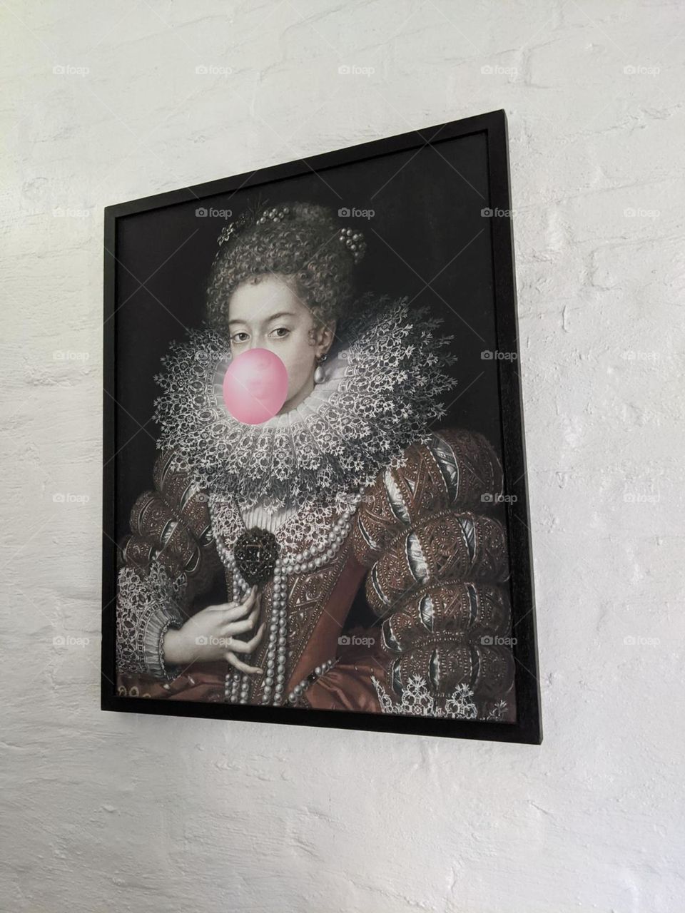 bright pink bubblegum bubble on a portrait of a Victorian queen on a whitewashed brick wall at an airbnb, pink wall art