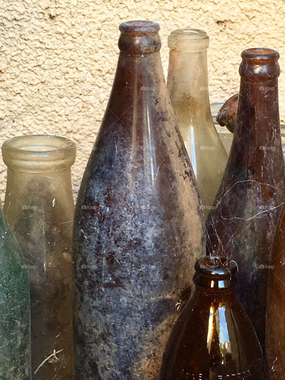 Eclectic collection of antique and vintage bottles in the state in which they were found unearthed in the backyard 