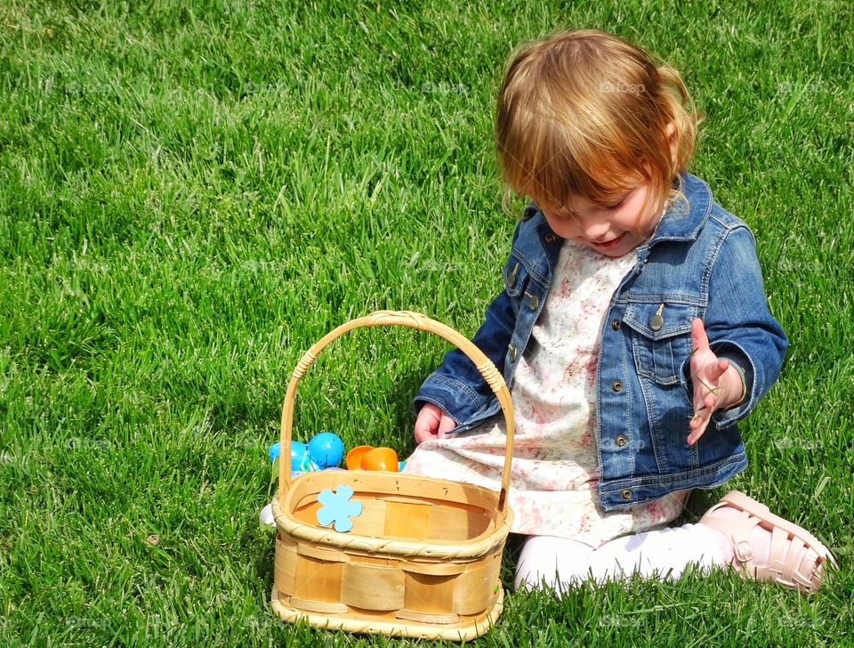 Easter Egg Hunt. Young Redhead Girl With Easter Basket Full Of Eggs
