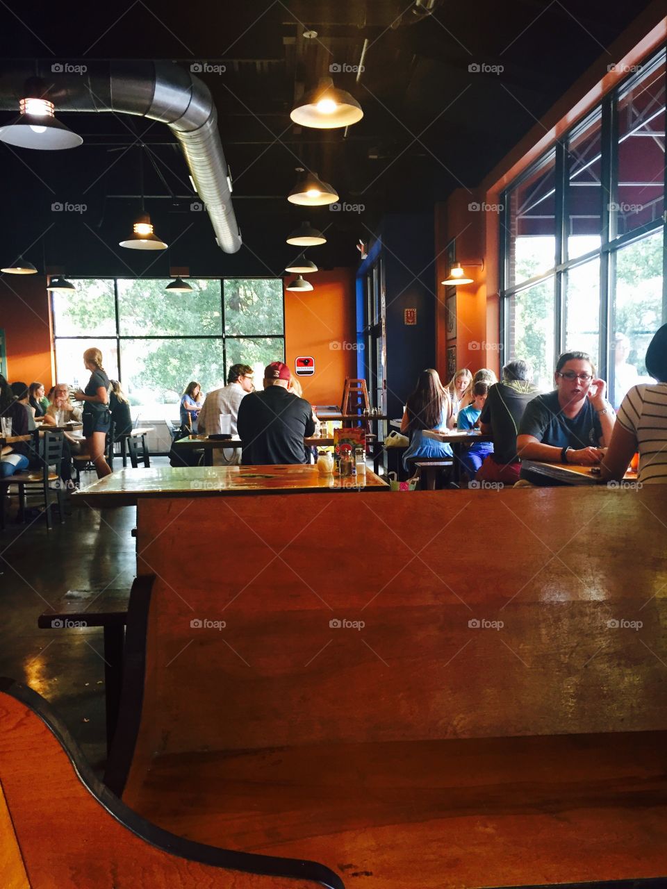 Modern restaurant people eating at tables with large windows