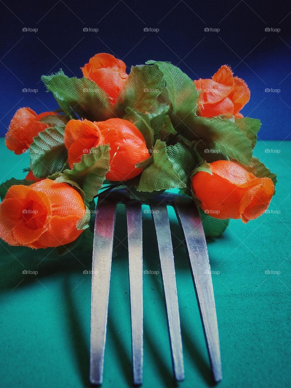 with an ordinary fork you use and abuse your creativity. Using some neon roses on a green surface and blue background, the result is this beautiful photo.