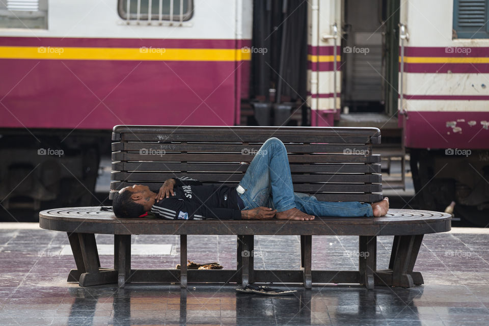 Man sleeping in the Hua Lamphong railway station in Bangkok Thailand 