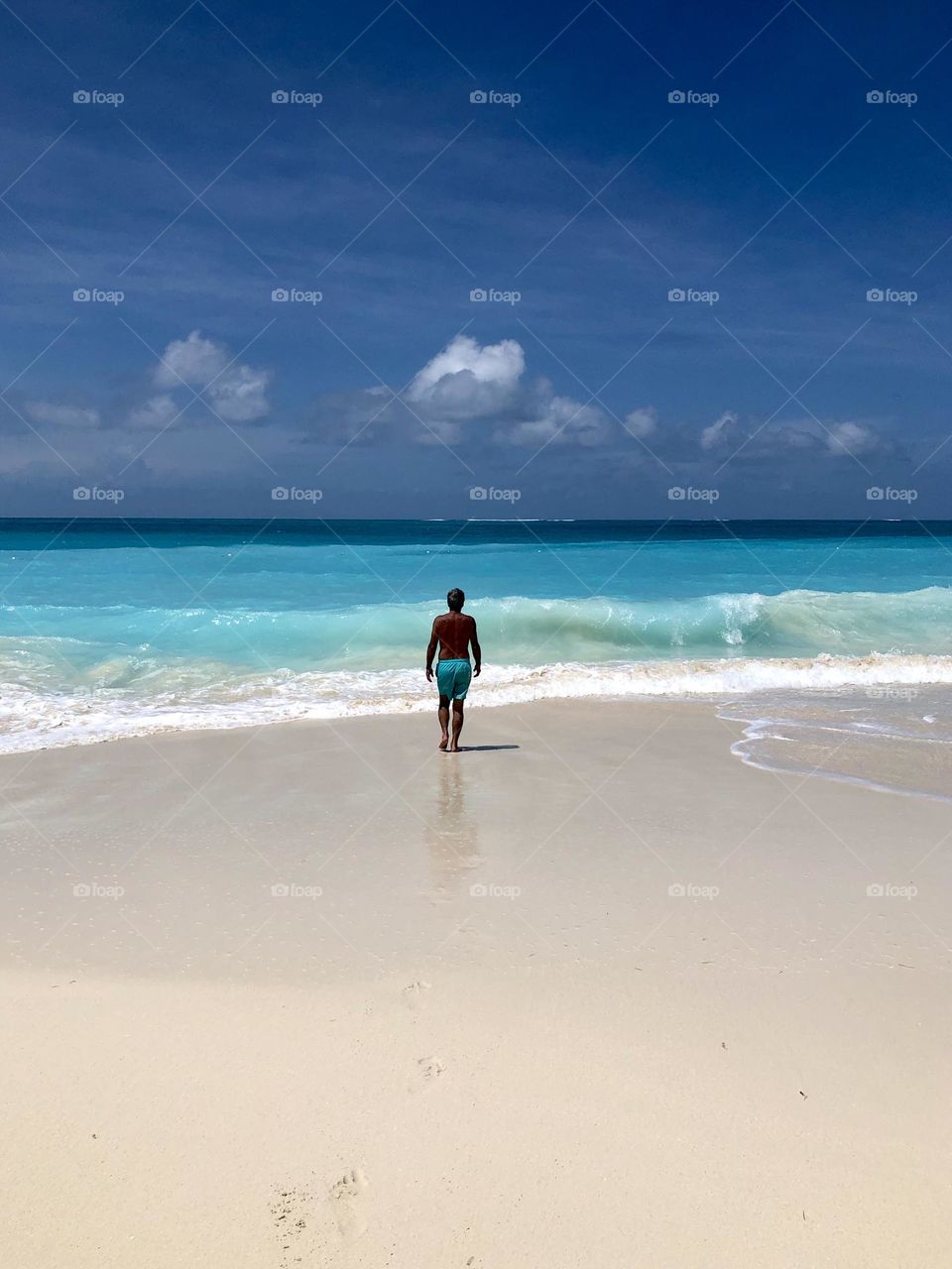 Man walking into Caribbean Sea