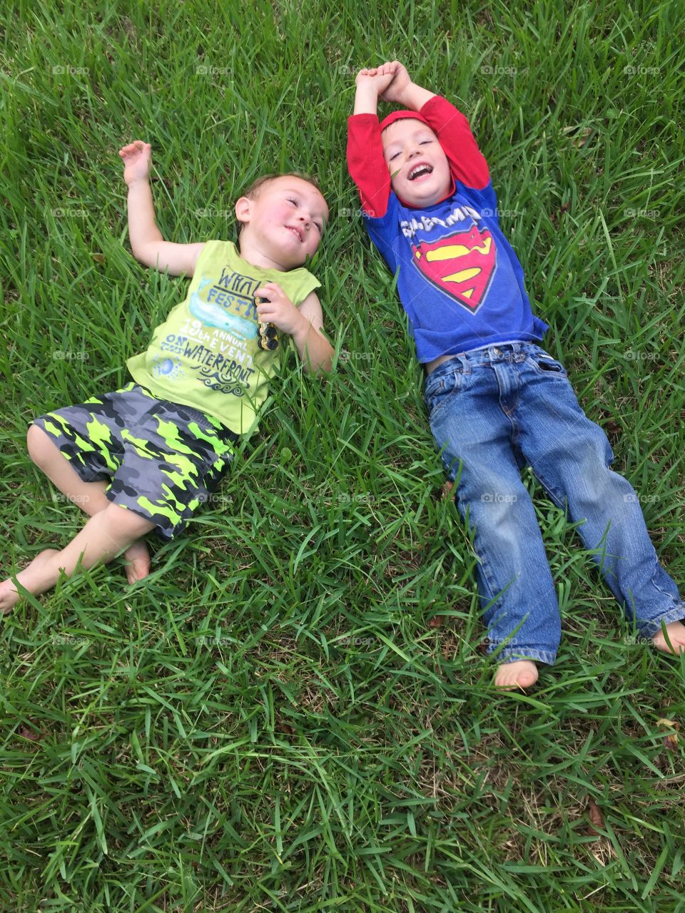 Boys having fun playing in the grass in the front yard