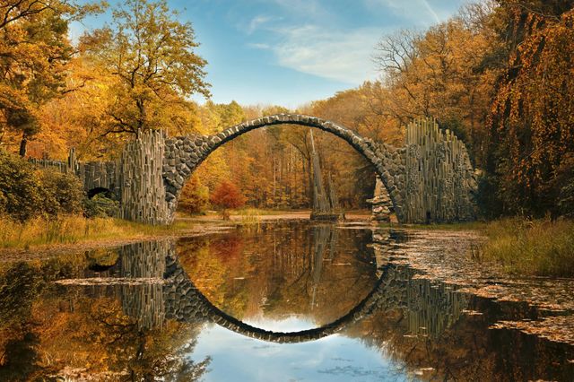 Round bridge with reflection in autumn park