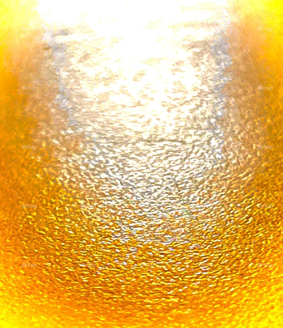 An edited photo of sun hitting a textured orange table.