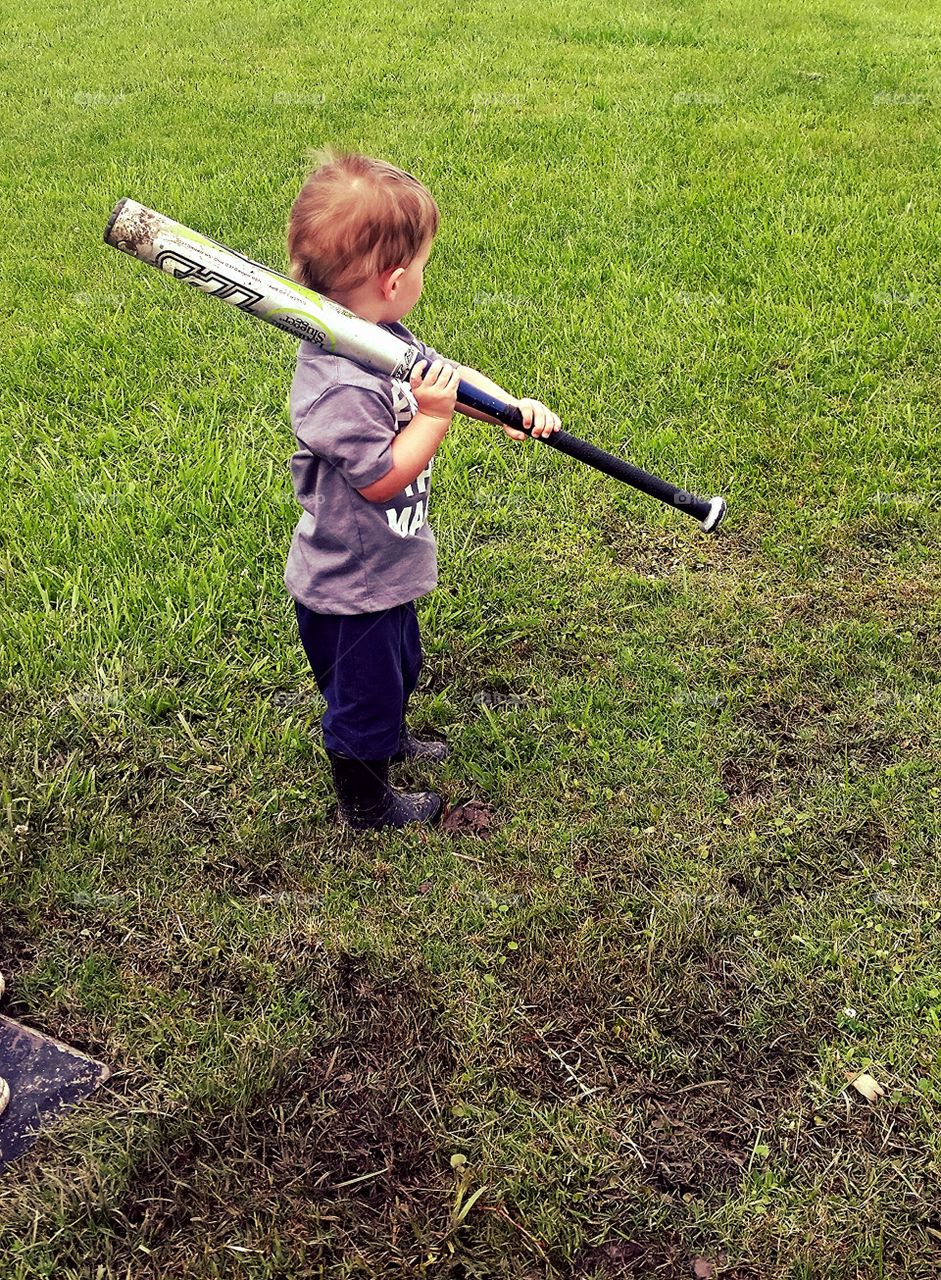 A Boy, his boots and his bat. rainy day batting practice