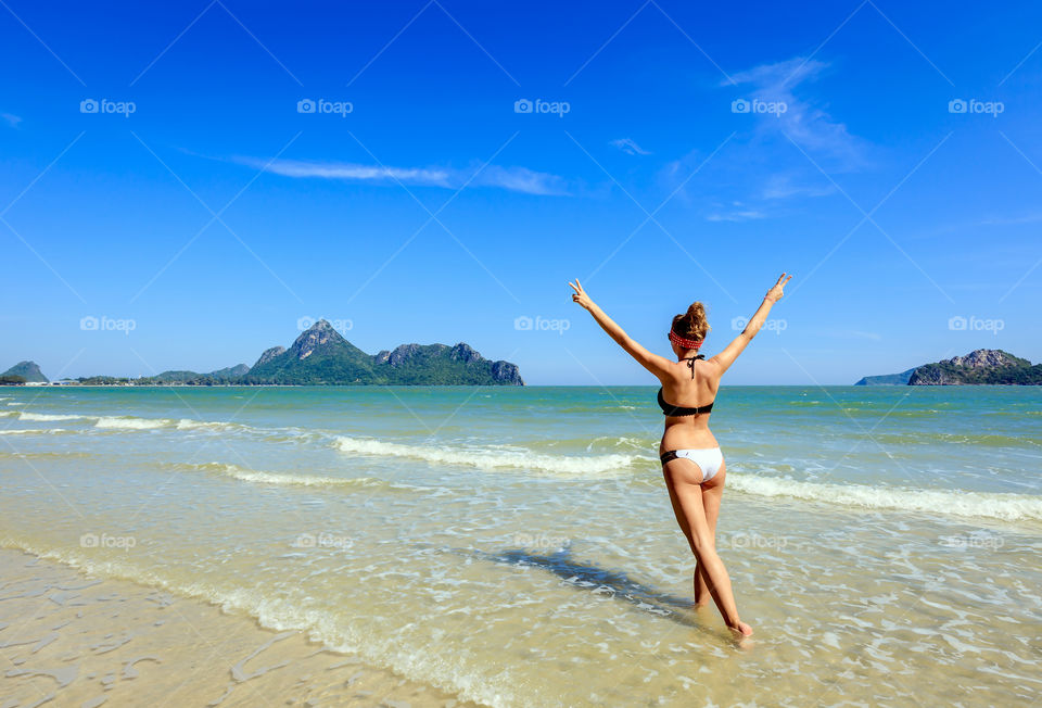 Rear view of woman enjoying at beach