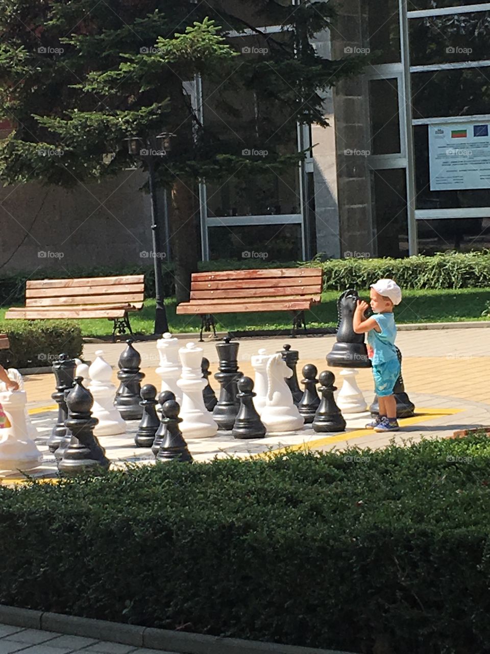 Child playing with chess players on chess board 