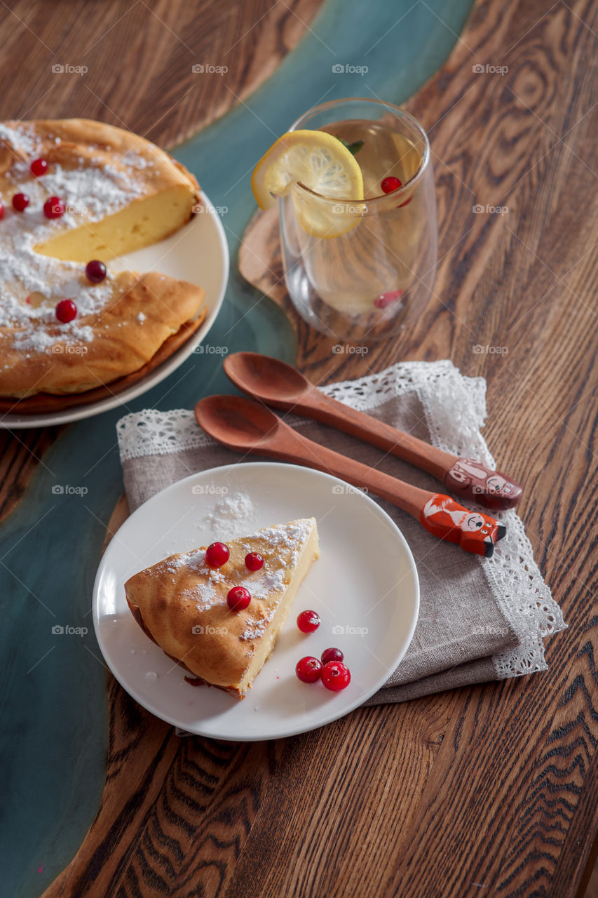 Cheesecake with cranberries and sugar on wooden background