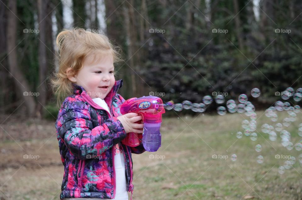 Asian cute girl playing with bubble gun