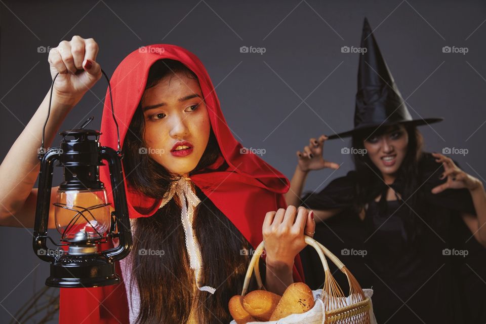 A lost girl in red hood being chased by a witch