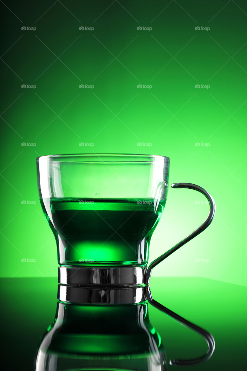 Fresh and healthy Green tea in a cup on green background.