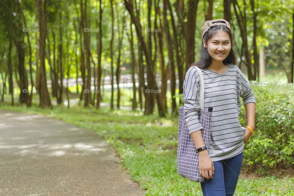An Asian girl walks in a tropical zoo in Thailand.