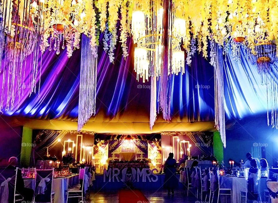 Wedding reception creative set up with illuminating blue and yellow lights effect.