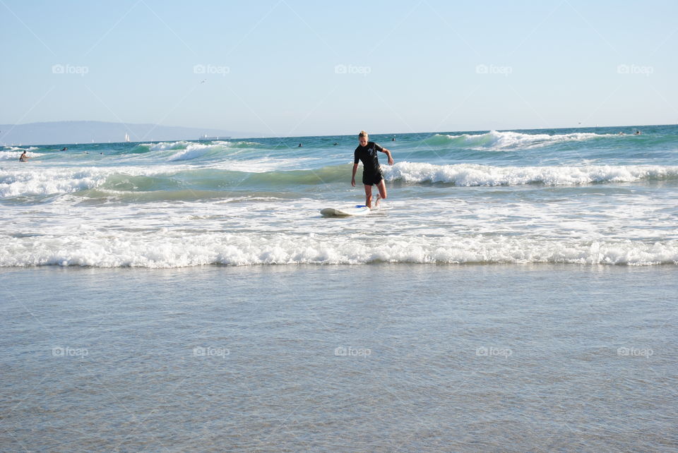 A surfer coming out of the water at Venice beach