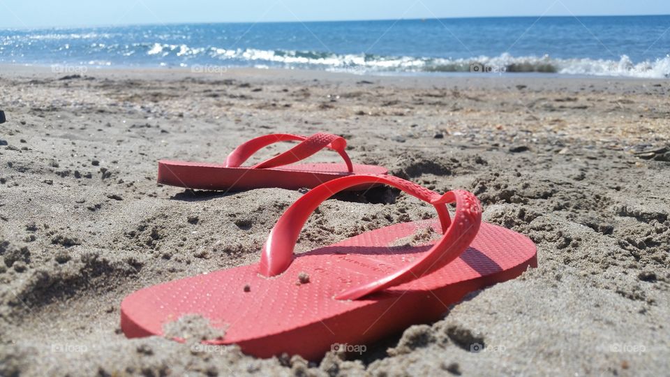 slippers on a beach and sea