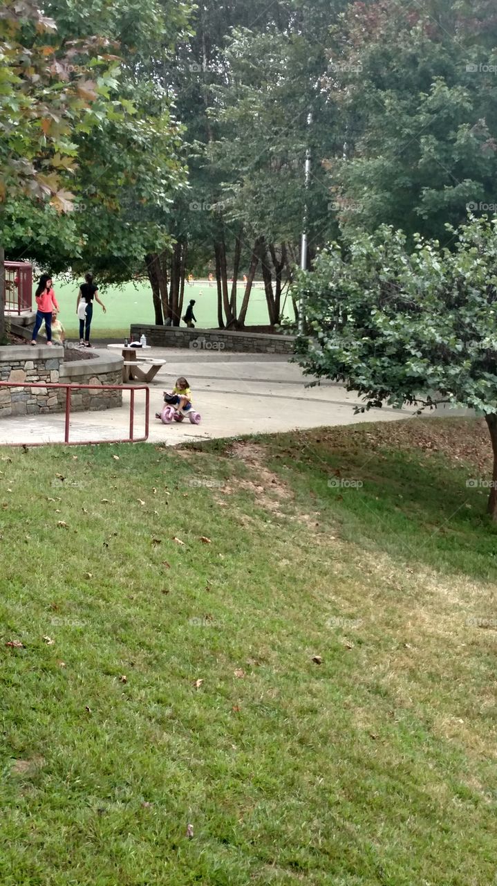 kids riding little scooter in the park
