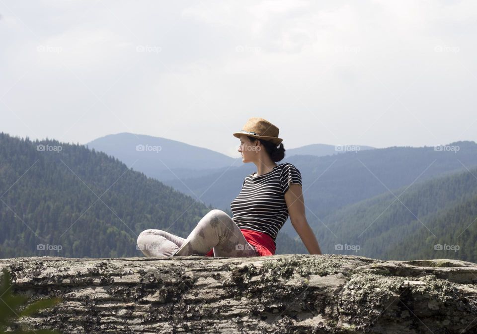 Woman sitting on the rock in the mountain