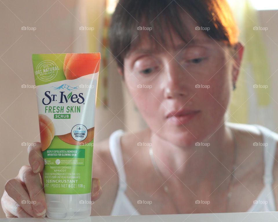 Caucasian woman holding St.Ives beauty product