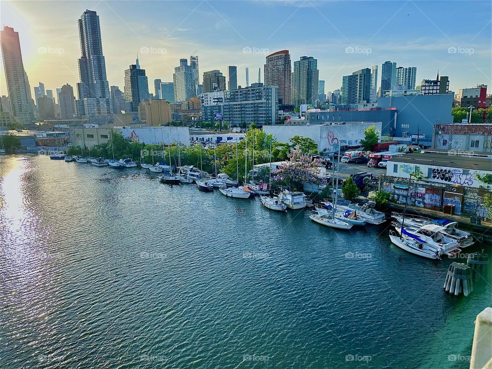 This is “Newtown Creek” seen from the “Pulaski Bridge” that connects LIC, Queens to “Greenpoint”, Brooklyn. In the distance across the “East River” we see the “Manhattan” skyline. 2024. Hypnotic Productions