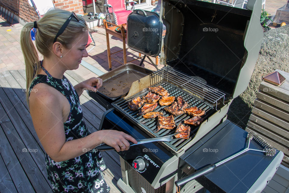 Woman cooking at the barbecue in Höllviken Sweden.