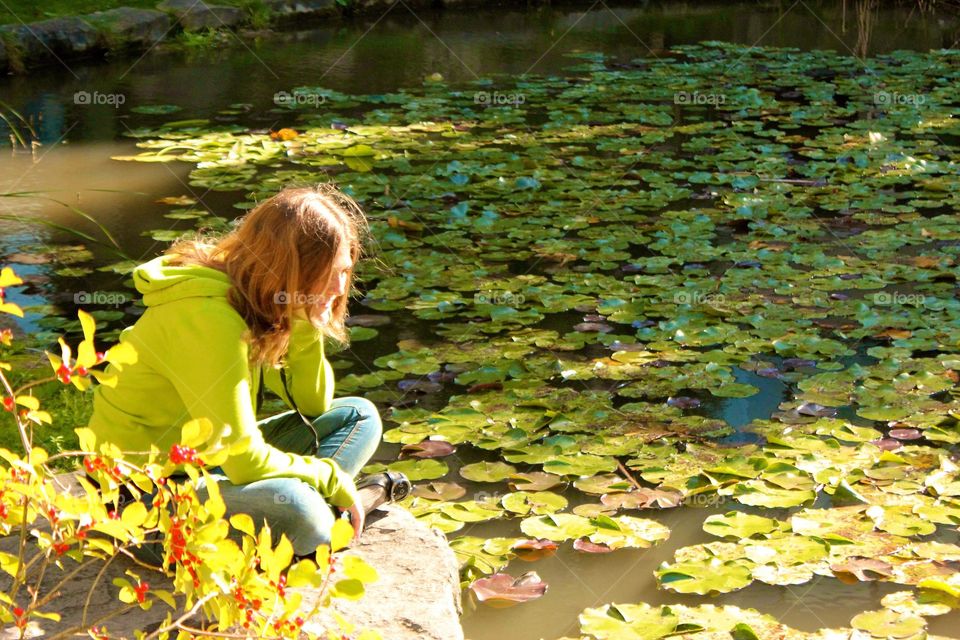 Young woman admiring a pond in summer