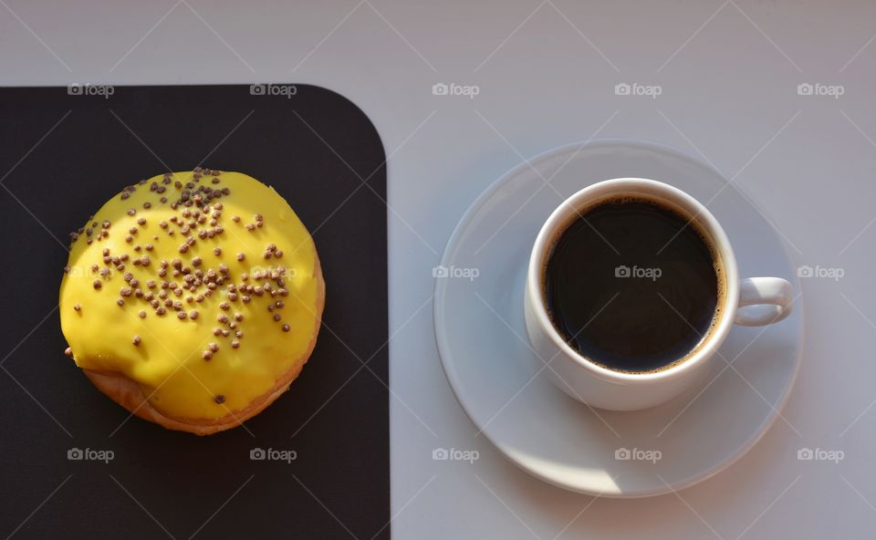 cup of coffee and sweet bun in sunlight top view beautiful texture on a white and brown background, morning routine, lifestyle