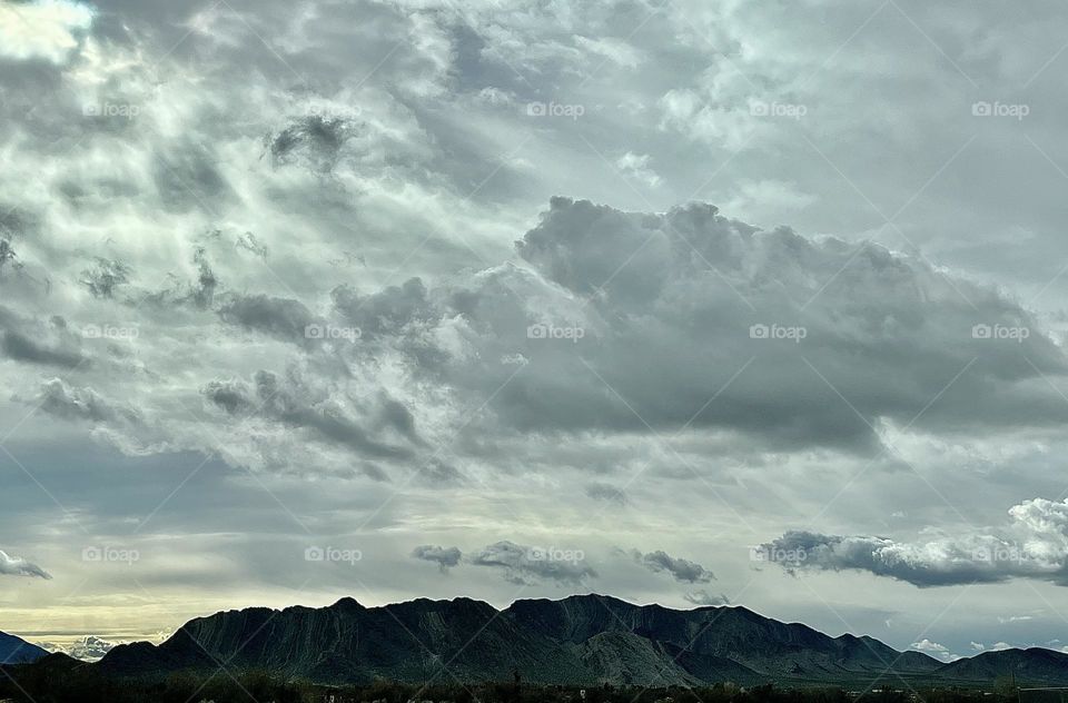 A photo of a cloudy sky above mountains. 