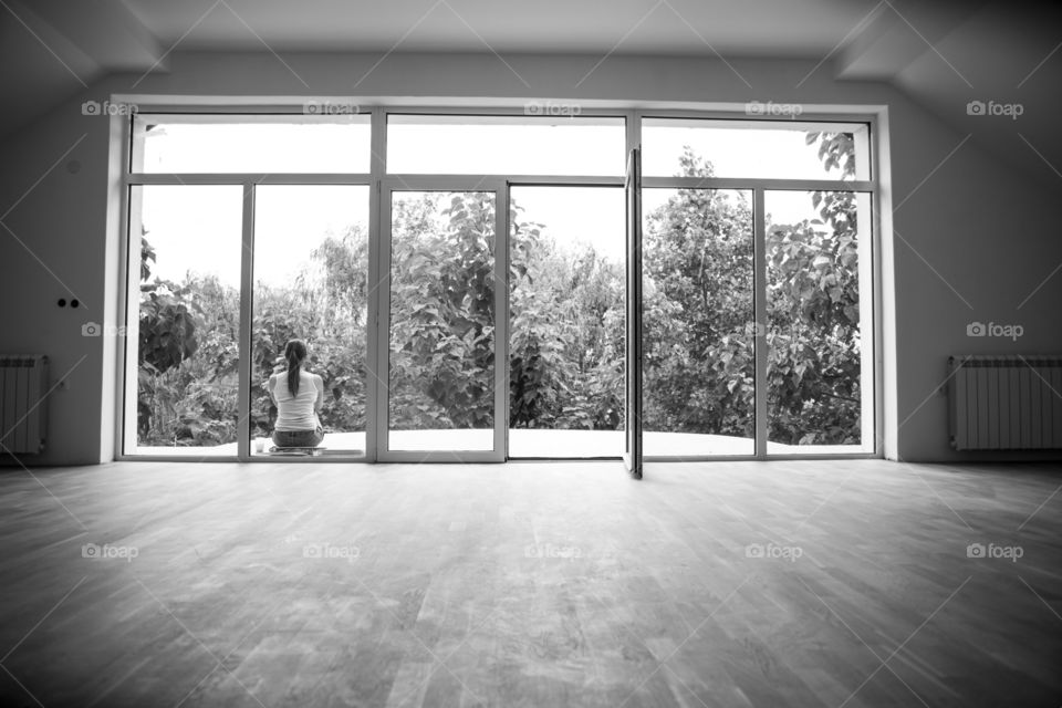 Rear view of woman sitting near window