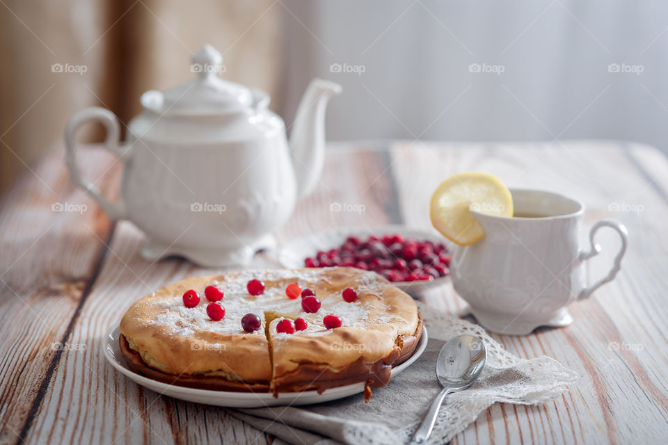 Cheesecake with cranberries and sugar on wooden background