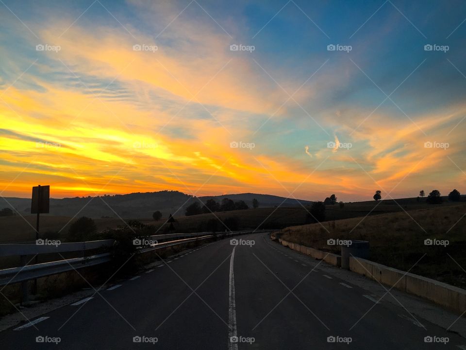 Empty road in the mountains at golden hour time