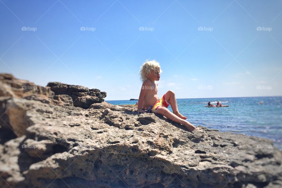 Boy sitting on a cliff