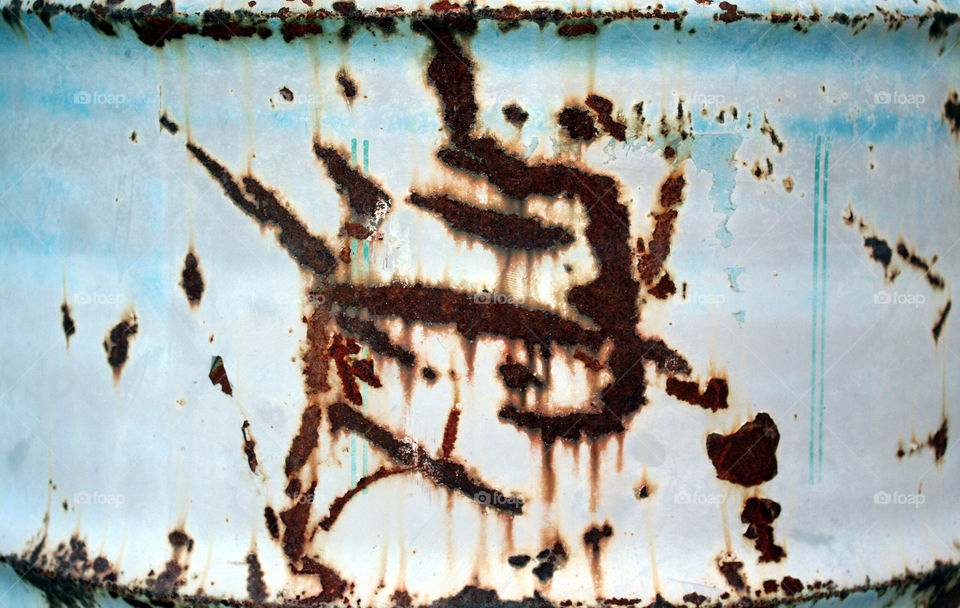 writings on the wall. rust on a park trash can