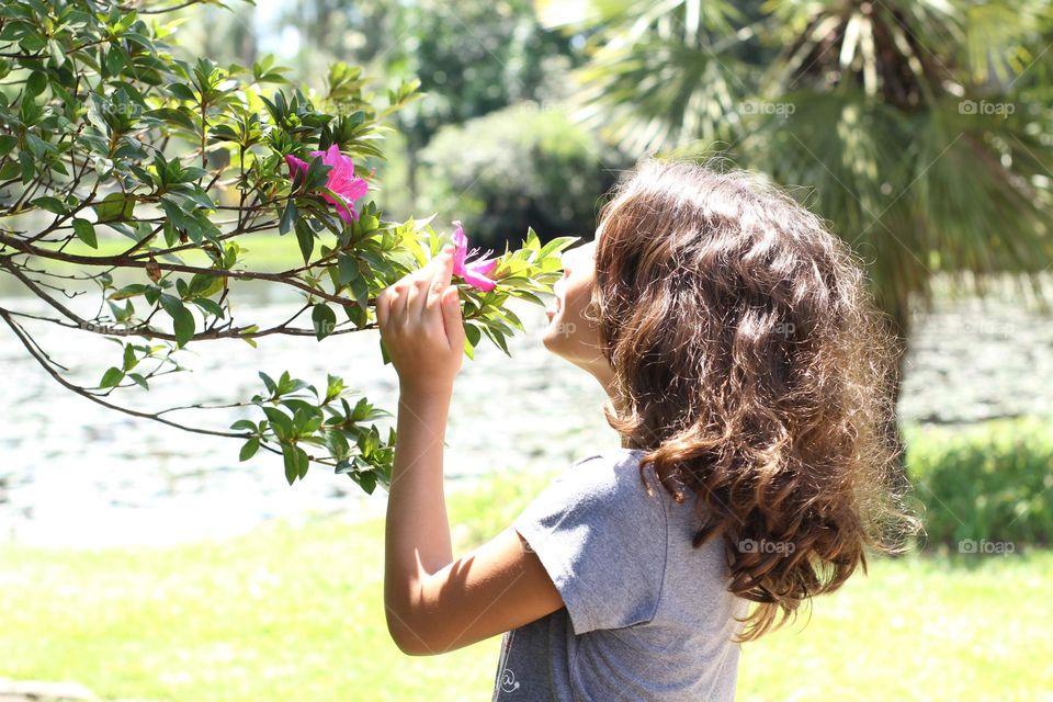 Girl smelling a flower in the parle