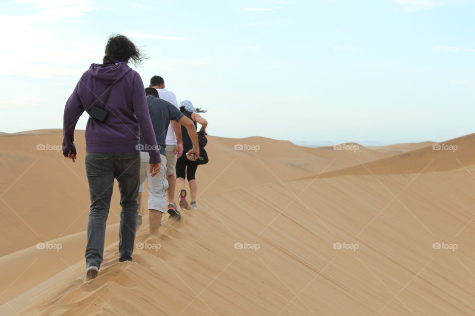 Group of people walking on sand dunes