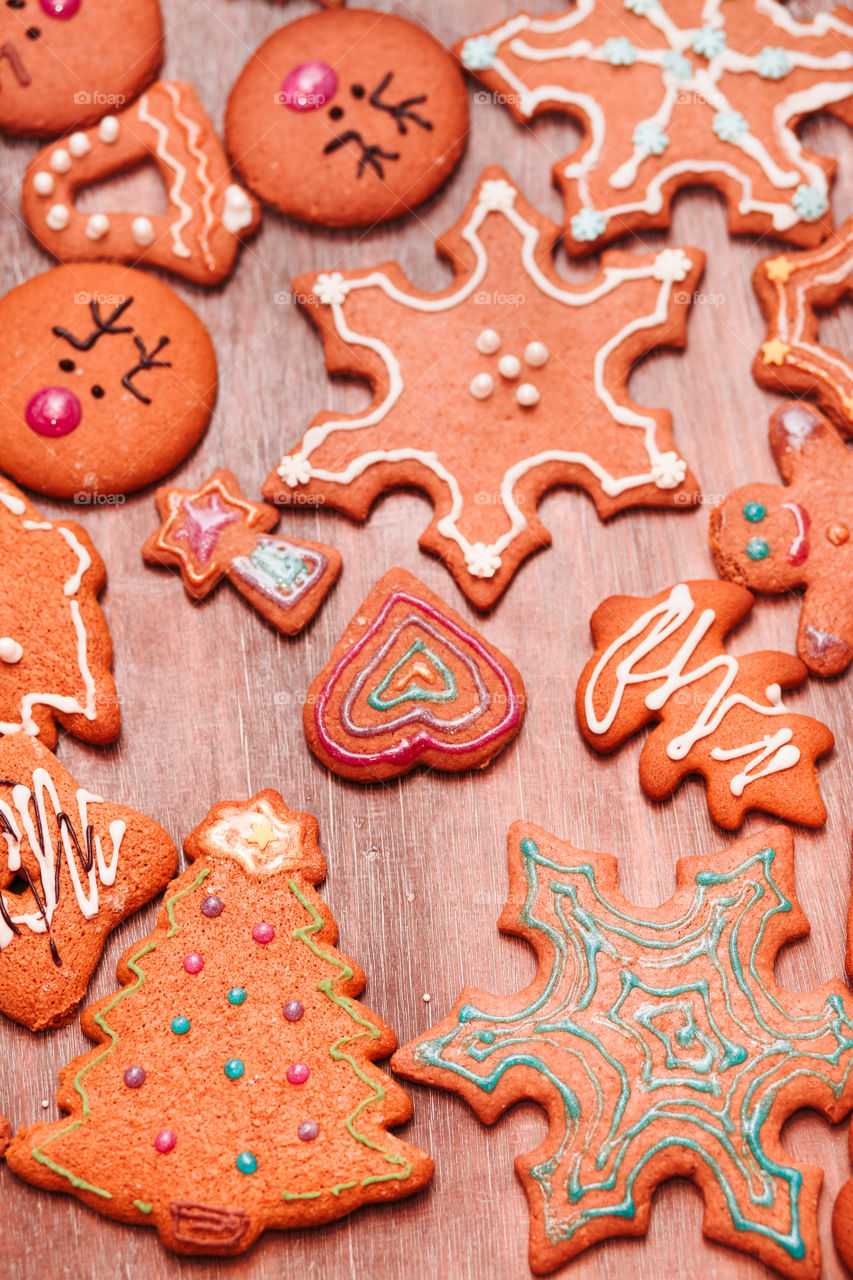 Christmas cookies decorated with frosting on wooden board